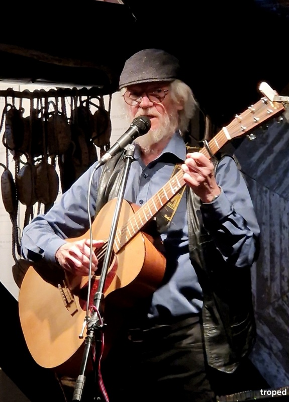Ragnar Olsen på scene med gitar og mikrofon.